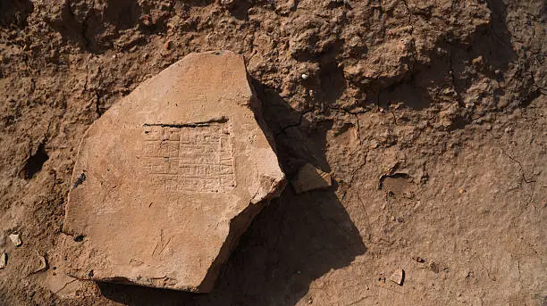 Archaeologists examining an ancient artifact in a dusty dig site.